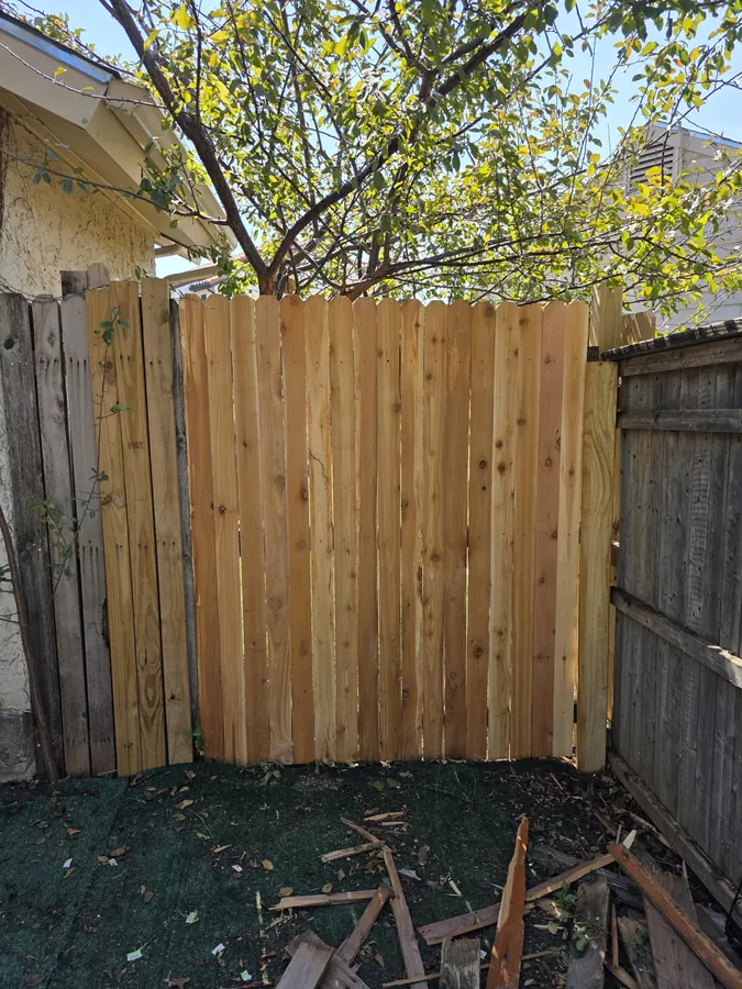New wood fence panel installed along a residential property line